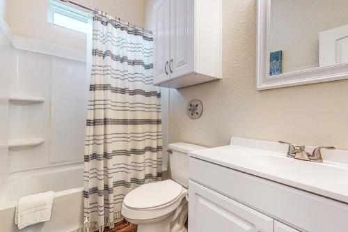 a white bathroom with a toilet and a sink at The Captain's Quarters in Rockport