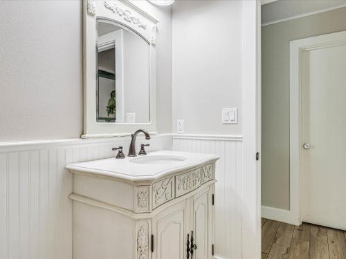 a white bathroom with a sink and a mirror at Oak Cottages 4 in Rockport