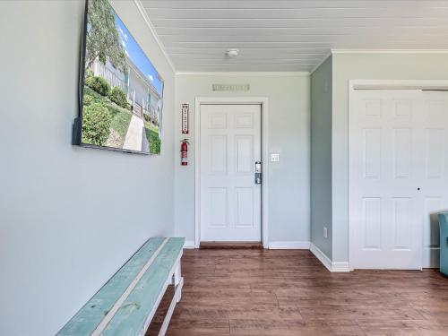korytarz z ławką i białymi drzwiami w obiekcie Oak Cottages 1 w mieście Rockport