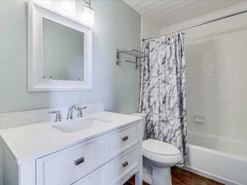uma casa de banho branca com um lavatório e um WC em Oak Cottages 1 em Rockport