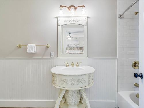 Baño blanco con lavabo y espejo en Oak Cottages 3 en Rockport