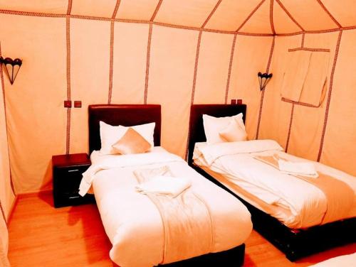 a room with two beds in a tent at Blue Sky Luxury Camp in Merzouga