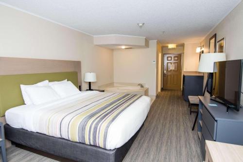a hotel room with a bed and a flat screen tv at Country Inn & Suites by Radisson, Lehighton-Jim Thorpe, PA in Lehighton