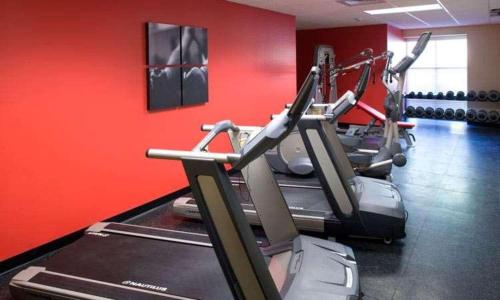 a gym with cardio machines in a red wall at Country Inn & Suites by Radisson, Knoxville at Cedar Bluff, TN in Knoxville