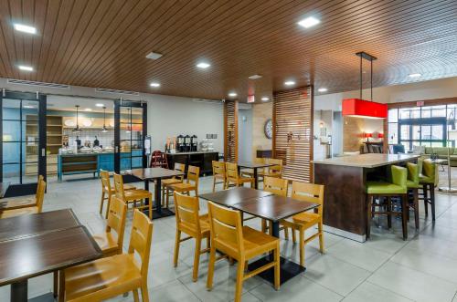 a restaurant with tables and chairs and a kitchen at Country Inn & Suites by Radisson, Charlottesville-UVA, VA in Charlottesville