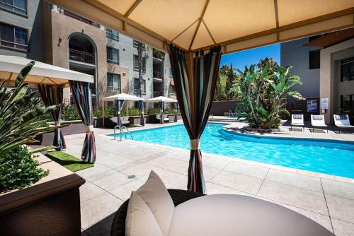 a swimming pool with umbrellas and a swimming pool at Woodland Hills Luxury Apt 2 bed CA in Los Angeles