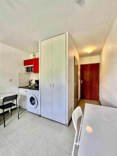 une cuisine avec une machine à laver et une table dans l'établissement Pratique, Proche Gare & Petit Prix avec Parking, à Grenoble