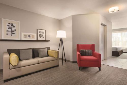 a living room with a couch and a red chair at Country Inn & Suites by Radisson, Germantown, WI in Germantown