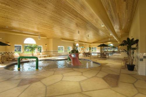 eine große Lobby mit einem Pool in der Mitte eines Gebäudes in der Unterkunft Country Inn & Suites by Radisson, Green Bay East, WI in Green Bay