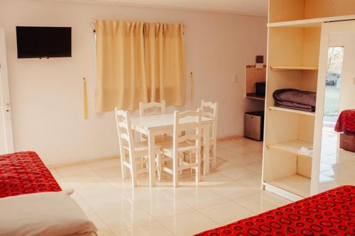 HOTEL REALICO في Realicó: غرفة نوم مع طاولة وكراسي في غرفة