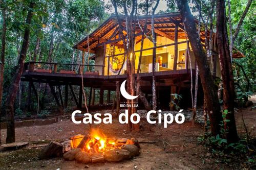 a tree house in the woods with a fire at Espaço Rio da Lua - Casas - Cipó, Mata, Madeira e Tororão - São Jorge GO in Sao Jorge
