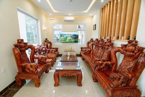 Vân Dương hotel في Kon Von Kla: غرفة معيشة مع كراسي خشبية وطاولة