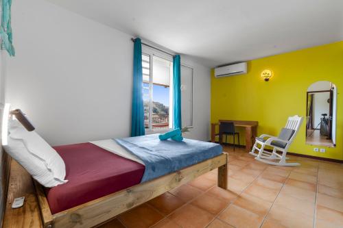 a bedroom with a bed and a table and chairs at Vert Ocean in Le Marin