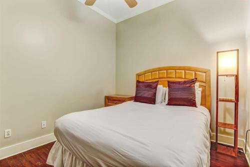 - une chambre avec un grand lit blanc et des oreillers violets dans l'établissement Loft steps from River Street and City Market, à Savannah