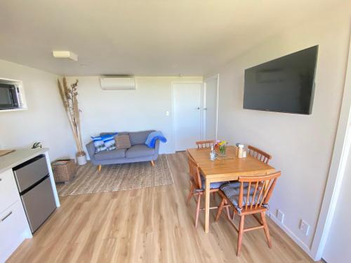 a living room with a table and a couch at Parapara's Seaview Retreat in Parapara 