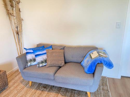 a couch with pillows in a living room at Parapara's Seaview Retreat in Parapara 