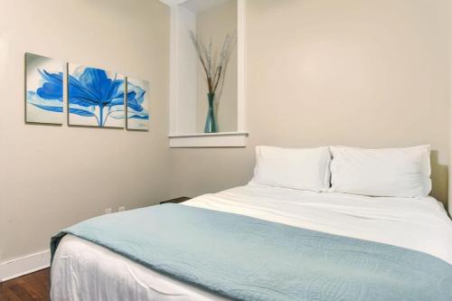 a bedroom with a white bed with a blue blanket at E Bay St Loft by City Market and River Street in Savannah