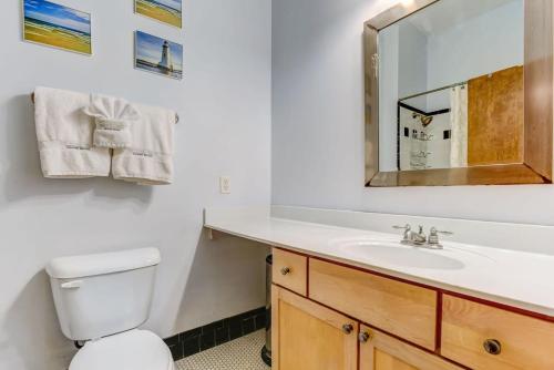 a bathroom with a sink and a toilet and a mirror at E Bay St Loft by City Market and River Street in Savannah