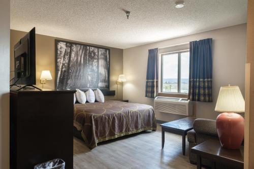 a hotel room with a bed and a window at Super 8 by Wyndham Grants in Grants