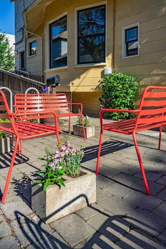 three red benches sitting in front of a house at Charming 1bd Suite in Capitol Hill - Foxglove Inn in Seattle