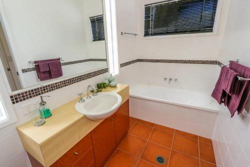 un baño con lavabo y bañera en BankSea Holiday Home, en Agnes Water