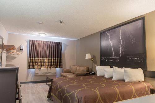 a hotel room with a bed and a couch at Super 8 by Wyndham Grants in Grants