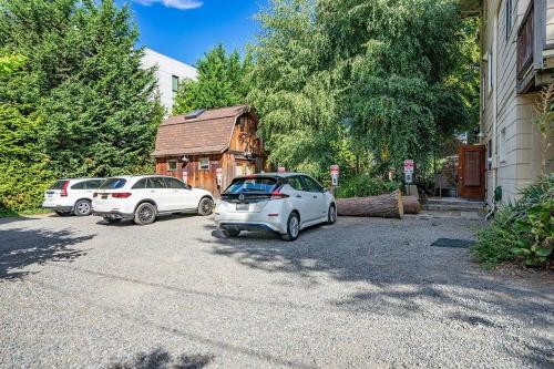 two cars parked in a parking lot next to a building at Charming Room in Capitol Hill - Foxglove Inn Rm 6 in Seattle