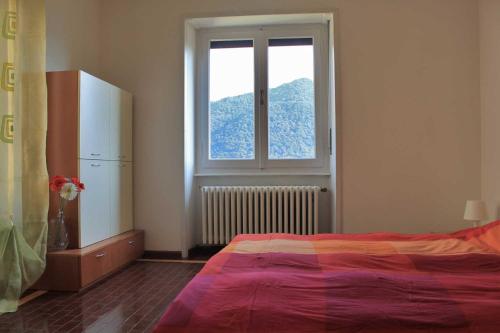 a bedroom with a bed and a window at La Piudana Como Lake in Ponna Superiore
