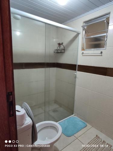uma casa de banho com um chuveiro e um WC. em Cantinho Dias Dutra em Angra dos Reis