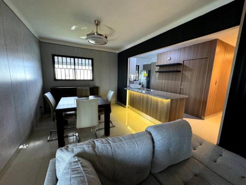 ein Wohnzimmer und eine Küche mit einem Sofa und einem Tisch in der Unterkunft Cozy 2 Bedroom Apartment. in Santo Domingo