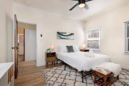 a white bedroom with a bed and a table at Exquisite 1BR Suite ahead of Cedar-Sinai Hospital in Los Angeles