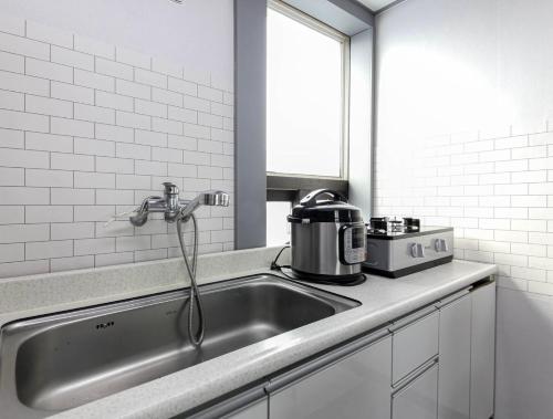 a kitchen with a sink and a toaster on a counter at Sokcho Sinabro in Sokcho