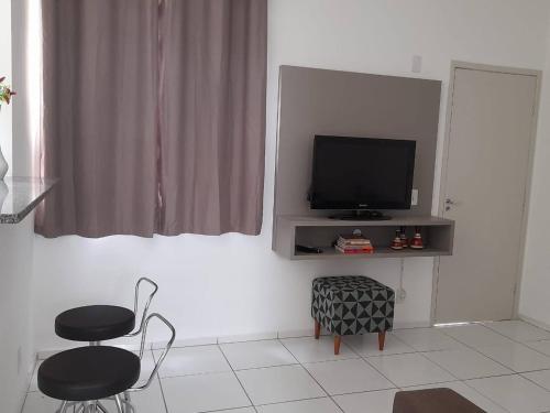 een woonkamer met een televisie en 2 stoelen bij Apartamento Completo - Res Pq Humanita - Bl 02 in Uberlândia