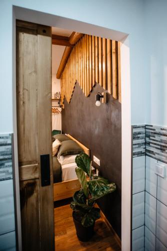 a bedroom with a bed and a door with a plant at Skyway Borsec Connection Hideaway in Borsec