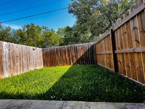 a fence with a green lawn in front of it at Haven Hideaway-Apartment 4 in Pharr