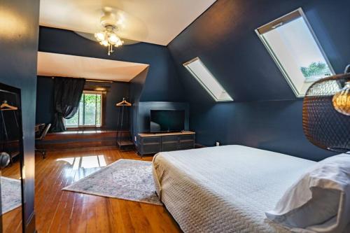 a bedroom with blue walls and a bed and a tv at Charming Room in Capitol Hill - Foxglove Inn Rm 8 in Seattle