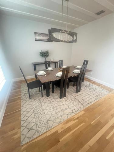 a dining room with a table and chairs on a rug at ※ Cul-de-Sac Haven, Stylish & Tranquil ~ King Beds in Forney