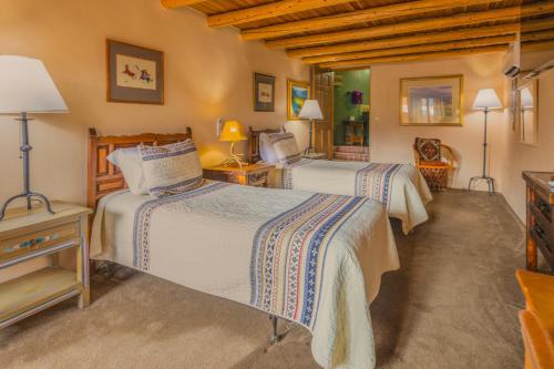 a bedroom with two beds and a television at Casa Benavides Inn in Taos