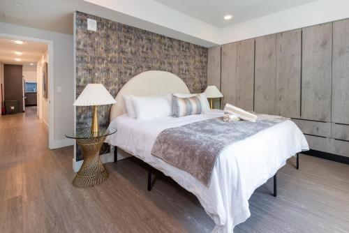 a bedroom with a large white bed and a lamp at Luxurious 2BR Condo in K-town w/ Private Balcony! in Los Angeles