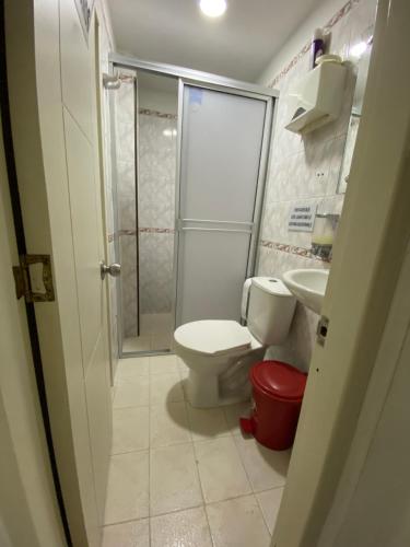a small bathroom with a toilet and a shower at Apartamento central primer piso in Apartadó