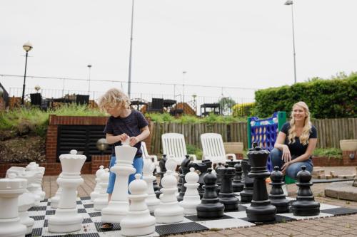 a boy and a girl playing chess on a chessboard at Delta Hotels by Marriott Heathrow Windsor in Windsor