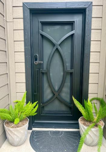 a black door on a house with two potted plants at ※ Cul-de-Sac Haven, Stylish & Tranquil ~ King Beds in Forney