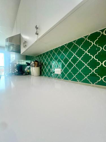 a kitchen with green tile on the wall at ※ Cul-de-Sac Haven, Stylish & Tranquil ~ King Beds in Forney