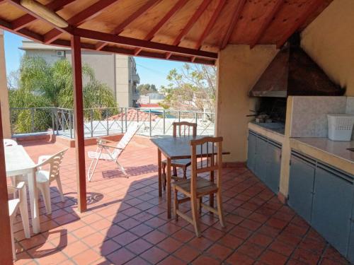 een patio met een tafel en stoelen en een keuken bij Life Departamentos in Guaymallen