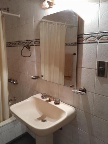 Un baño con un lavabo blanco y un espejo. en Un ambiente cómodo y placentero, en Guaymallén