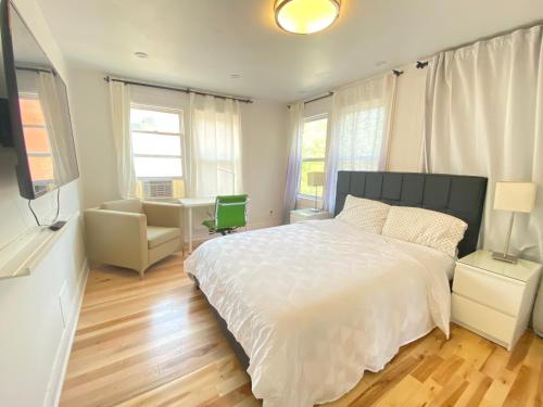 a bedroom with a white bed and a desk at SAI GON Suit in Grimsby