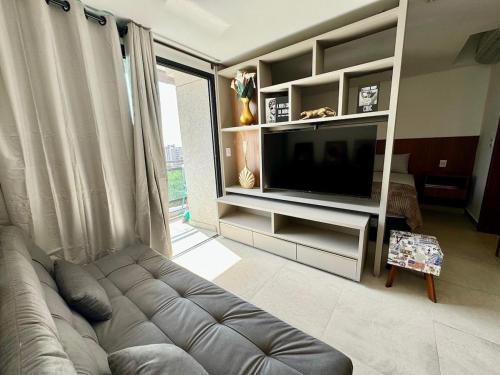 a living room with a couch and a television at Monte Carmel in Ribeirão Preto