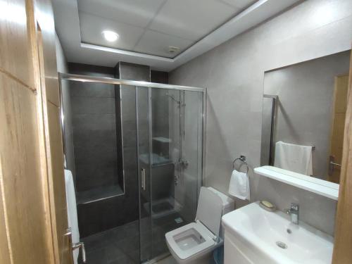 a bathroom with a shower and a toilet and a sink at Hotel Residence Ramsis in Nador