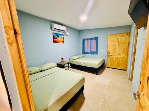 a bedroom with two beds and a door to a room at Hostal Camila’s in Tamanique