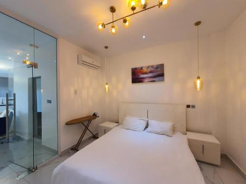 a bedroom with a white bed and a glass wall at The Vittins in Tantra Hill